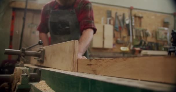 O mestre corta uma tábua de madeira com uma serra circular na oficina de marcenaria de um pequeno fabricante de móveis. Movimento lento. Fechar Vercion 3 — Vídeo de Stock