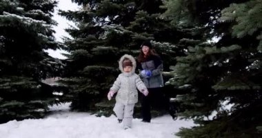 Ağır çekim. Neşeli gülümseyen çocuklar sokakta kartopu oynar, koşar ve kartopu atarlar.