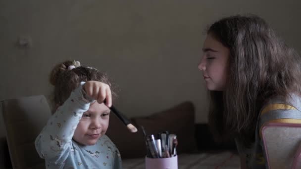Küçük kız makyaj fırçasıyla oynuyor ve arkadaşına nasıl makyaj yaptığını hayal ediyor.. — Stok video