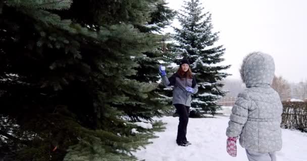 Повільний рух. Веселі діти грають у сніжки на вулиці — стокове відео