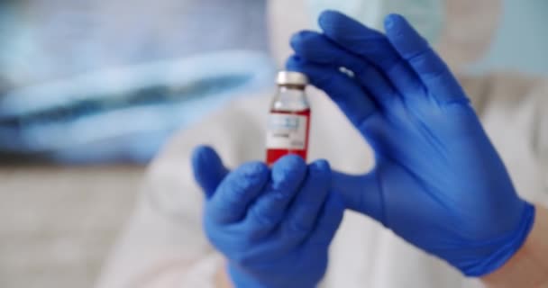 Врачи держат бутылку с красной ампулой в больнице. — стоковое видео