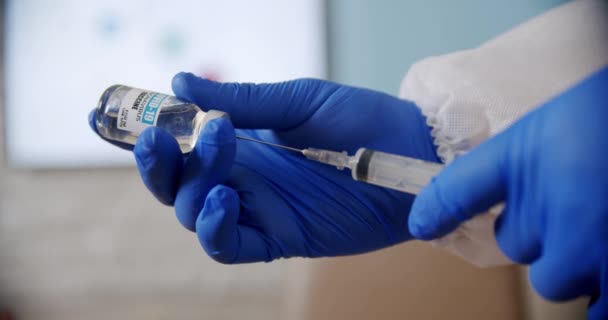 Врачи держат в больнице шприц и бутылку вакцины.. — стоковое видео