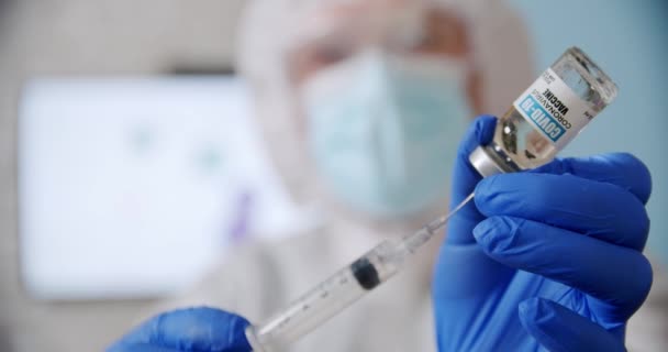 Blured doctors hand houdt een spuit en een fles vaccin vast in het ziekenhuis. — Stockvideo