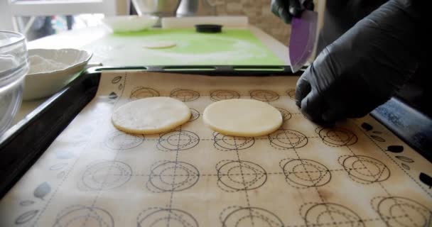 Las manos de chef con guantes negros cortan la masa en tiras estrechas con un cuchillo redondo especial, para preparar deliciosos pasteles. Movimiento lento — Vídeos de Stock