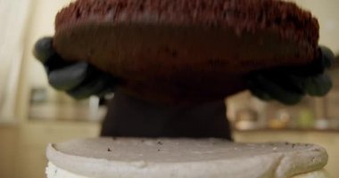 Kapatın. Pasta yapan kadın elleri bir sonraki pastayı üste koyar.