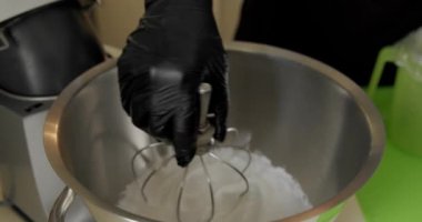 Pasta için çırpılmış süt kreması. Profesyonel fırıncı pasta hamurunu hazırlıyor, krema yapıyor. Yavaş çekim