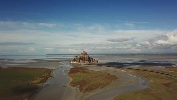 Flygdrönare syn på Le Mont Saint Michel, ikoniska ön och kloster på solig dag, Normandie, Frankrike Brett skott. Flytta kameran från vänster till höger — Stockvideo