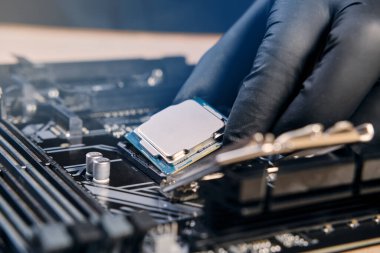 Bilgisayar veya dizüstü bilgisayarın prizine takmak için siyah eldiven işlemcisi işlemcisi içinde el ele tutuşan mühendis tamircisi