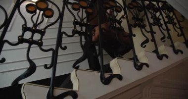 İş adamı evrak çantasını karanlık koridor boyunca taşıyıp merdivenlerden aşağı iniyor. Yavaş çekim