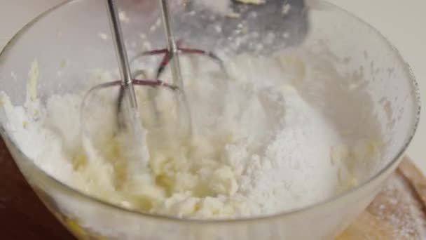 電気ミキサーを使用して生地ベーキングケーキを調理ボウルに材料を混合ベイカーのショットを閉じます, — ストック動画