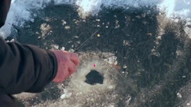 Güneşli kış günü için oltayı kapat. Balıkçılık buz Vercion 3 'te bir deliğe sıkıştı.