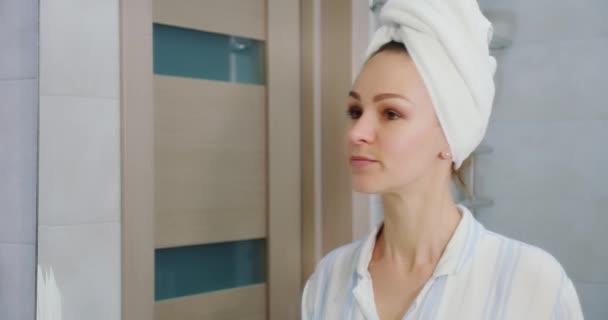 Attraktive Frau schminkt sich mit Pinsel und Wimperntusche und schaut im Badezimmer in den Spiegel — Stockvideo