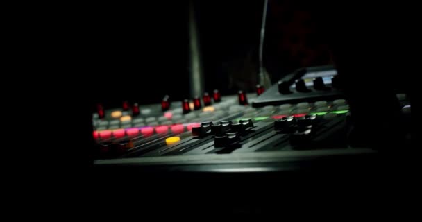 Close-up geluidsproducent hand is met behulp van een muziek mixer met editing tools in concert. — Stockvideo