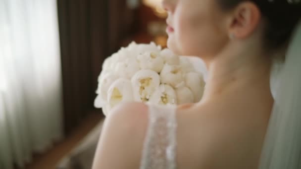 Le matin de la mariée dans une rose blanche tient dans ses mains un bouquet de roses de mariage. Vue du dessus — Video
