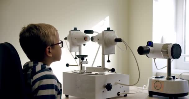 Optometrist verifica a visão das crianças usando o dispositivo médico da optalmologia. — Vídeo de Stock