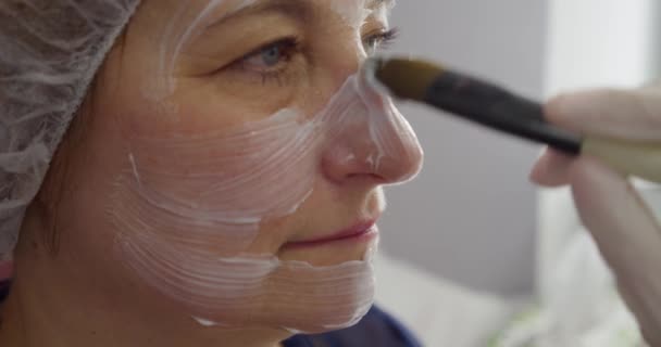 Close up. Old woman applied makeup visage by her makeup, skin care, applying cream — Stock Video