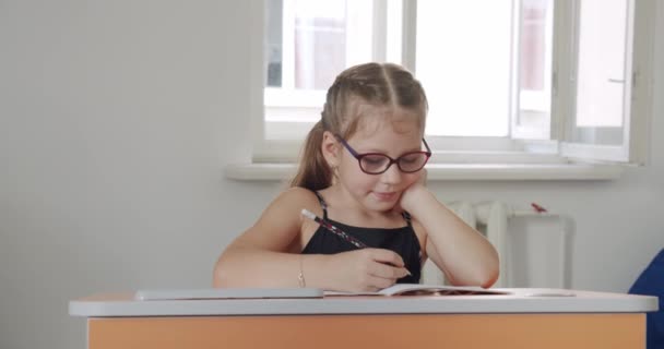 Portrait school kid siting on table doing homework, school and home schooling, — Stock Video
