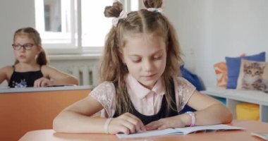 Portre okulu çocuğu masada oturuyor, ödev yapıyor, okul ve evde eğitim görüyor.,