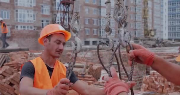 건축 봉사자들이 크레인에 자재를 부착하다. — 비디오