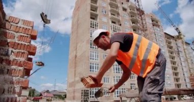 Erkek işçiler betonla duvara tuğla döşüyorlar. Sürüm 4