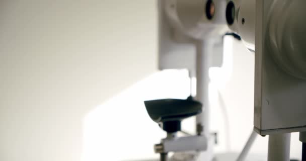 Ο οπτομέτρης ελέγχει την όραση των παιδιών χρησιμοποιώντας την οφθαλμολογική ιατρική συσκευή. Κλείσε. — Αρχείο Βίντεο