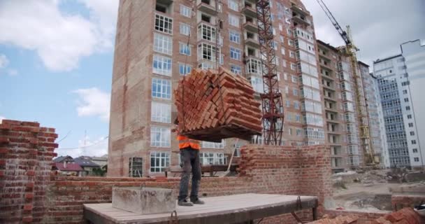 Construindo uma casa, um guindaste entrou com um palete de trabalho de tijolos. — Vídeo de Stock