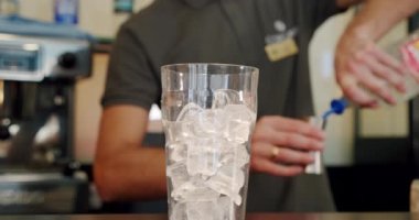 Cocktail hazırlamak için yakın plan. Ezilmiş buzlu bir bardakta, barmen sert alkol ve soda doldurur..