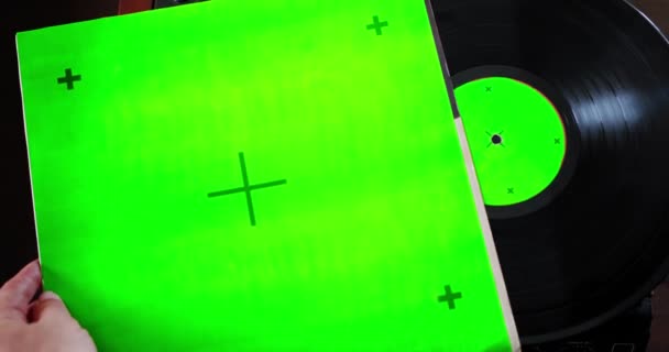 Gammal vinylspelare med chromakey, Man drar ut en vinylskiva och sätter den på spelaren, grön skärm, spårningspunkt. — Stockvideo