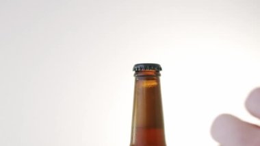 Beyaz arka planda bira şişesi açmak. Yavaş çekim