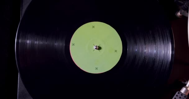 Fond vinyle noir avec un autocollant vert au centre, tournant en cercle. Vercion 6 — Video