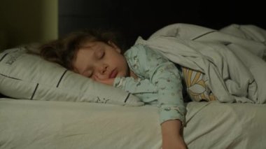 Tatlı küçük kız yatakta tek başına iyi uyuyor..