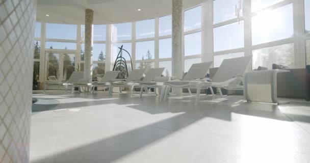 Empty sunbeds in the indoor swimming pool. Wide view — Stock Video