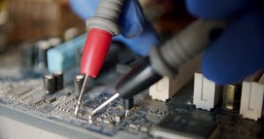 Elektronik onarım servisinde tamirci, test cihazının kullanılabilirliğini kontrol ediyor, kapatıyor.
