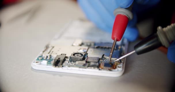Riparatore nel servizio di riparazione elettronica tramite il tester verifica la praticabilità del dispositivo, Close up Versione 2 — Video Stock