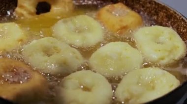 Ev yapımı donutları kızgın yağda kızartmak, abur cubur hazırlamak. Donut Sürüm 2 'nin üst görünümü