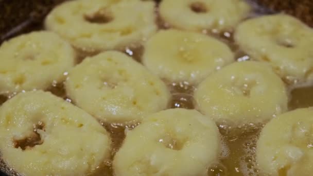 Het bakken van zelfgemaakte donuts op hete kokende olie, vet junk food bereiding. bovenaanzicht van donuts Versie 3 — Stockvideo