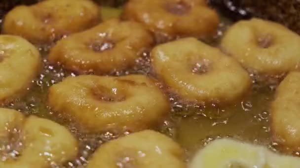 Fritar cozinhando donuts caseiros em óleo fervente quente, preparação de alimentos de lixo gordo. vista superior de rosquinhas Versão 4 — Vídeo de Stock