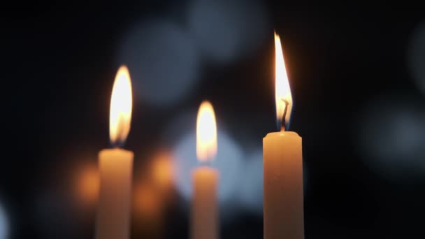 Záběry ze zapálení tří svíček na pozadí barevného rozmazaného zadku. Verze 2 — Stock video