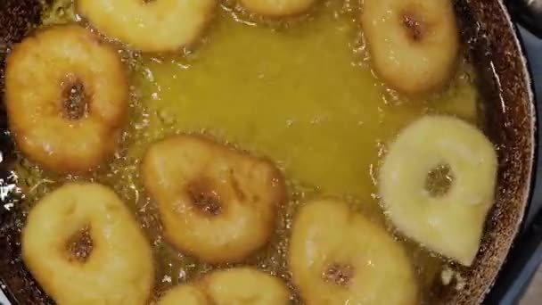 Fritar cozinhando donuts caseiros em óleo fervente quente, preparação de alimentos de lixo gordo. vista superior de rosquinhas Versão 6 — Vídeo de Stock