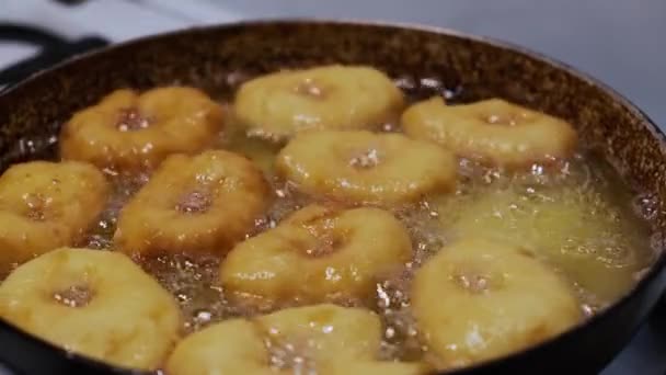 Жареные домашние пончики на горячем кипящем масле, приготовление жирной нездоровой пищи. верхний вид пончиков Версия 7 — стоковое видео