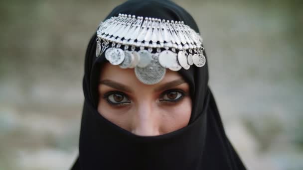 Gesicht mit Schmuck attraktiver muslimischer Frauen, die einen traditionellen Hijab-Schal tragen. Ihre Augen blicken in die Kamera. Version 2 — Stockvideo