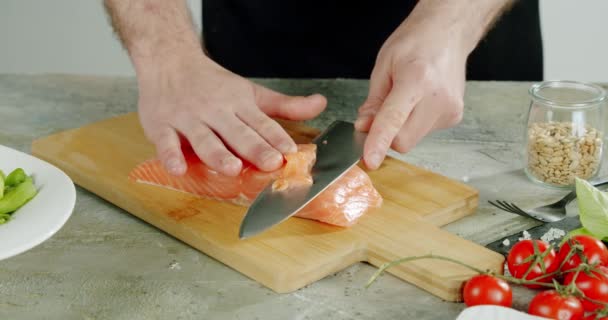シェフはナイフで魚を木の板にスライスし始めます. — ストック動画