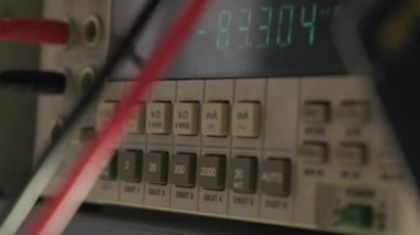 Siyah eldivenli elin yakın görüntüsü cihazı modern elektronik laboratuvarı, mikroişlemci osiloskobu ve multimetre 'deki bir elektronik tamir atölyesinde ayarlar..