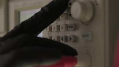 Siyah eldivenli bir el cihazı modern elektronik laboratuvarı, mikroişlemci osiloskobu ve multimetredeki bir elektronik tamir dükkanında ayarlıyor. Görüntüyü kapat