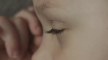 Yeşil gözlü küçük kızın profil görüntüsü kameraya bakıyor. Kapat.