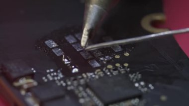 Kapatın. Tamir atölyesinde elektronik yenileme, ana kartta bir elektrik parçası.