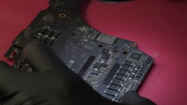 Tamir atölyesindeki elektronik yenileme görüntüsünü kapat. Bir uzmanın elinde dizüstü bilgisayar ana kartı.