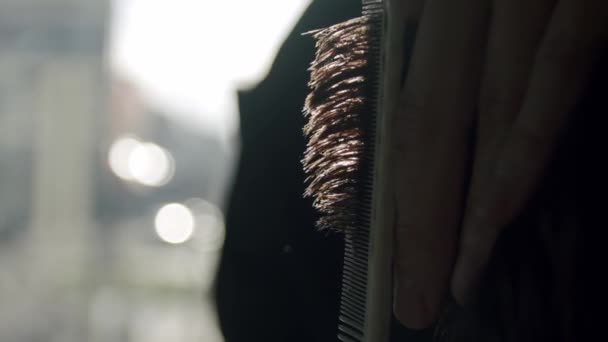 vue rapprochée du coiffeur coupe les cheveux des jeunes hommes avec des ciseaux. Mouvement lent