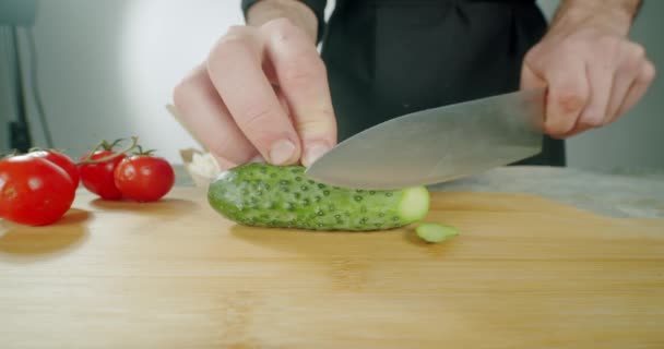 Cuchillo Cortar las verduras de pepino en la tabla de cortar de madera. Movimiento lento — Vídeos de Stock