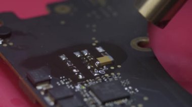 Tamir atölyesindeki elektronik yenilenmenin makro görüntüsünü kapat, ana kartta bir elektrik parçası bul.